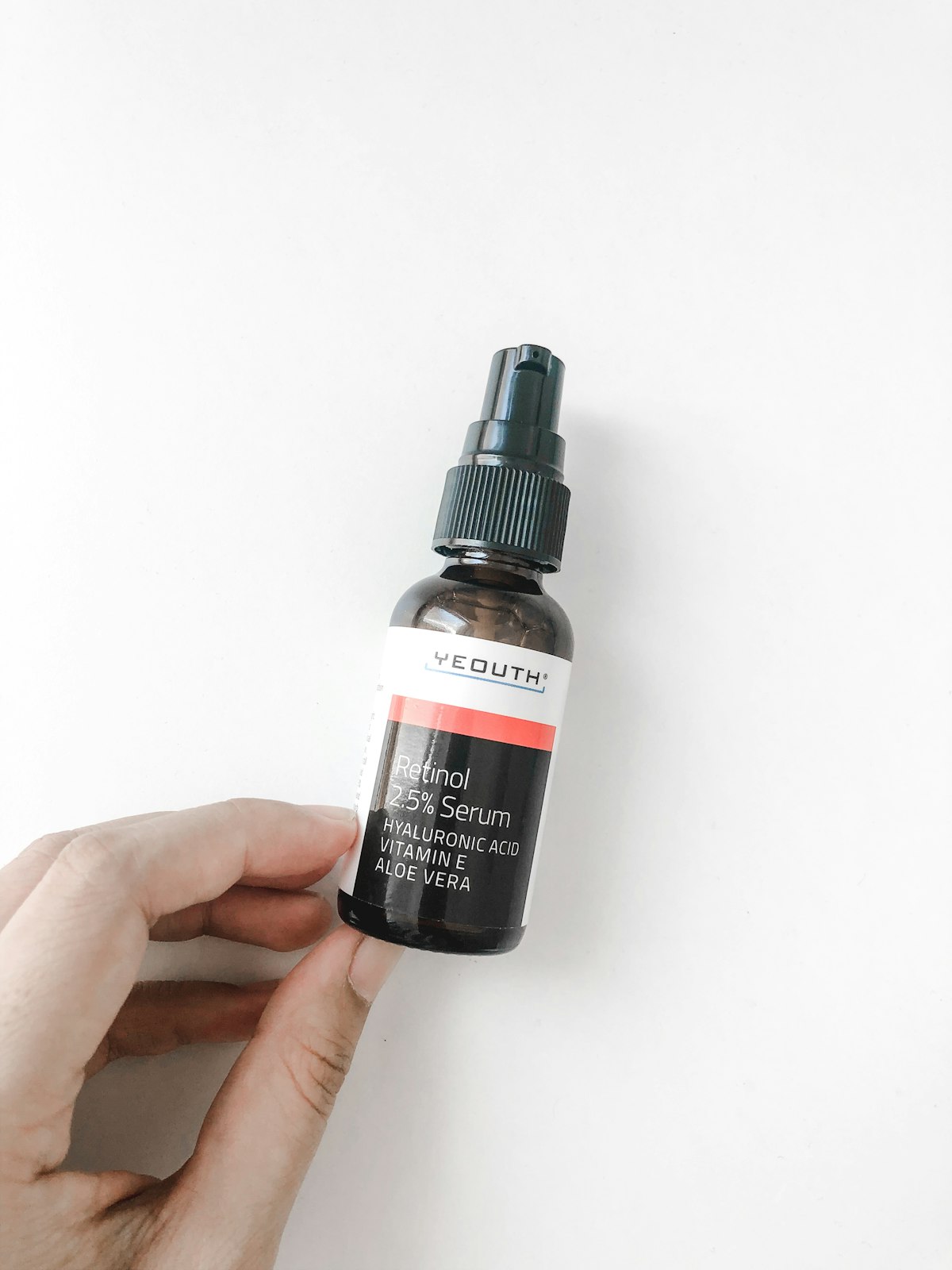 Frau haelt Hautpflegeprodukt in der Hand als Teil ihrer taeglichen Routine