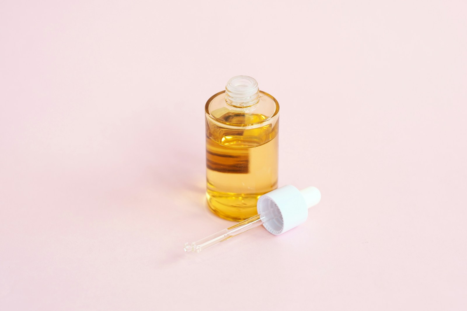 Hautpflegeserum mit Pipette auf rosa Hintergrund fuer die Mikrobiom-Pflege