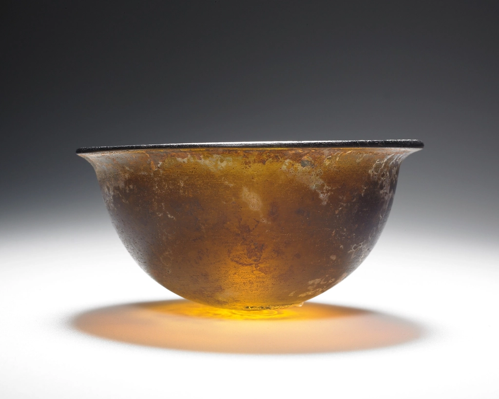 Braune Glasflaschen mit Pipetten stehen nebeneinander auf einer hellen Ablage vor schlichtem Hintergrund