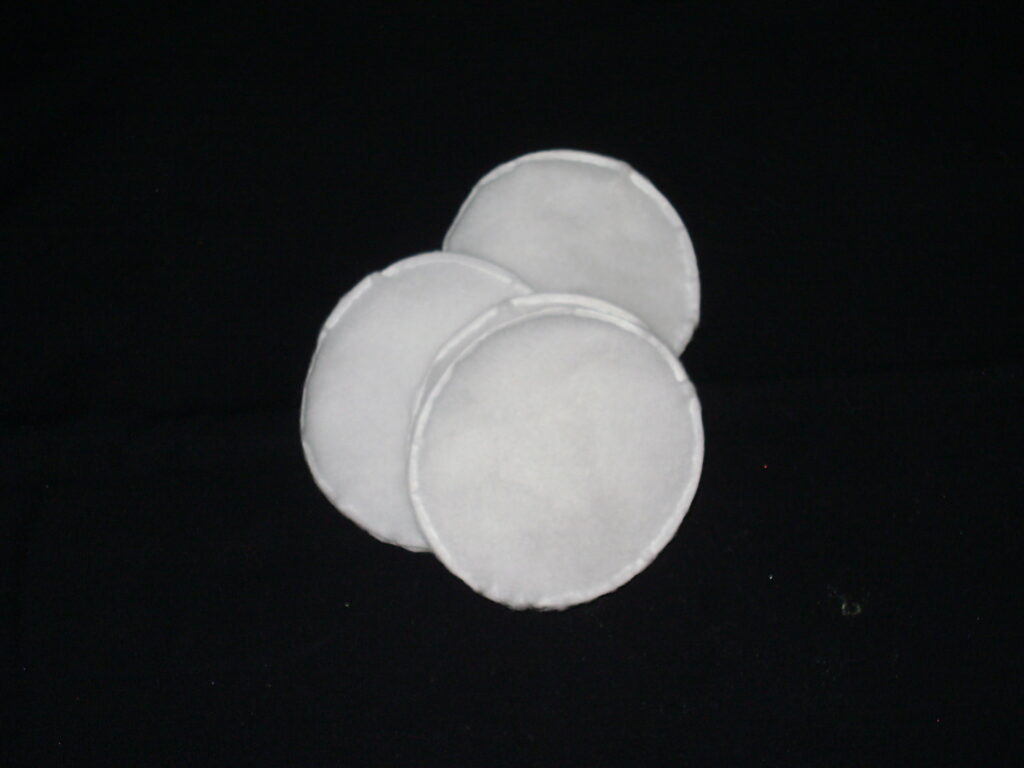 Wattepads liegen neben einer Flasche zweiphasigem Augen-Make-up-Entferner