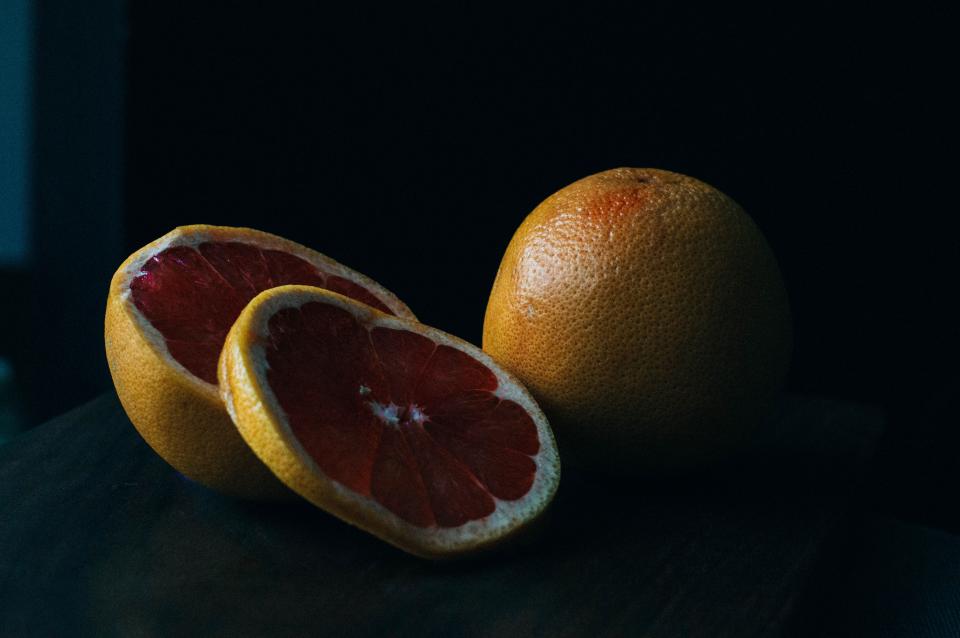 Aufgeschnittene Orangen und Zitronen liegen in einer Schale auf einem Tisch