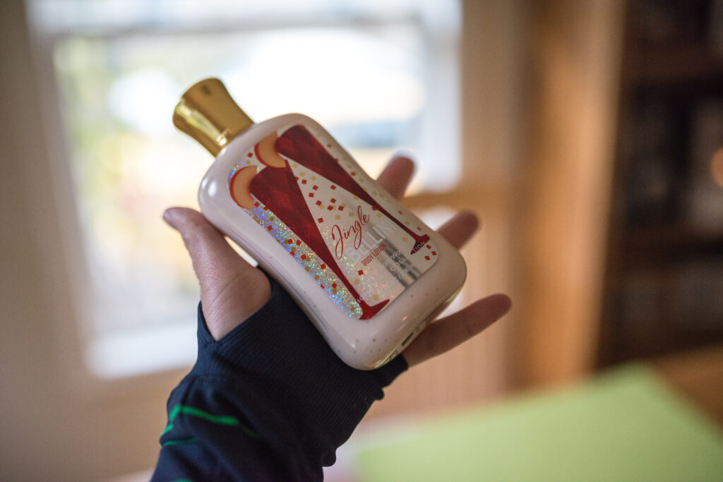 H&auml;nde tragen K&ouml;rperlotion auf den Unterarm auf, im Hintergrund ein Handtuch