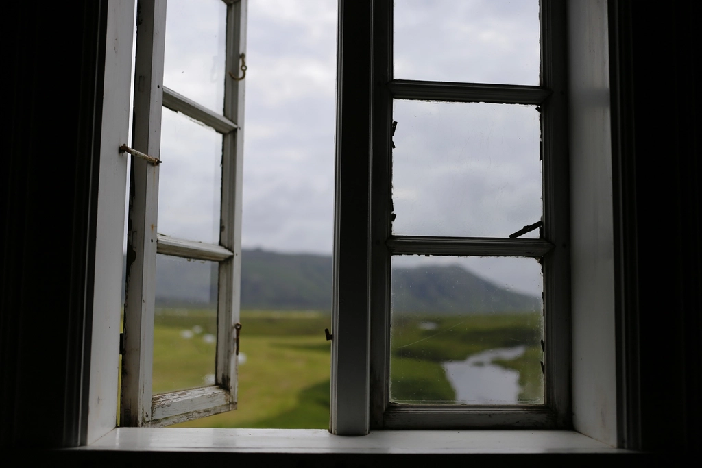 Weit ge&ouml;ffnetes Fenster in einem Wohnraum mit winterlicher Stra&szlig;e im Hintergrund
